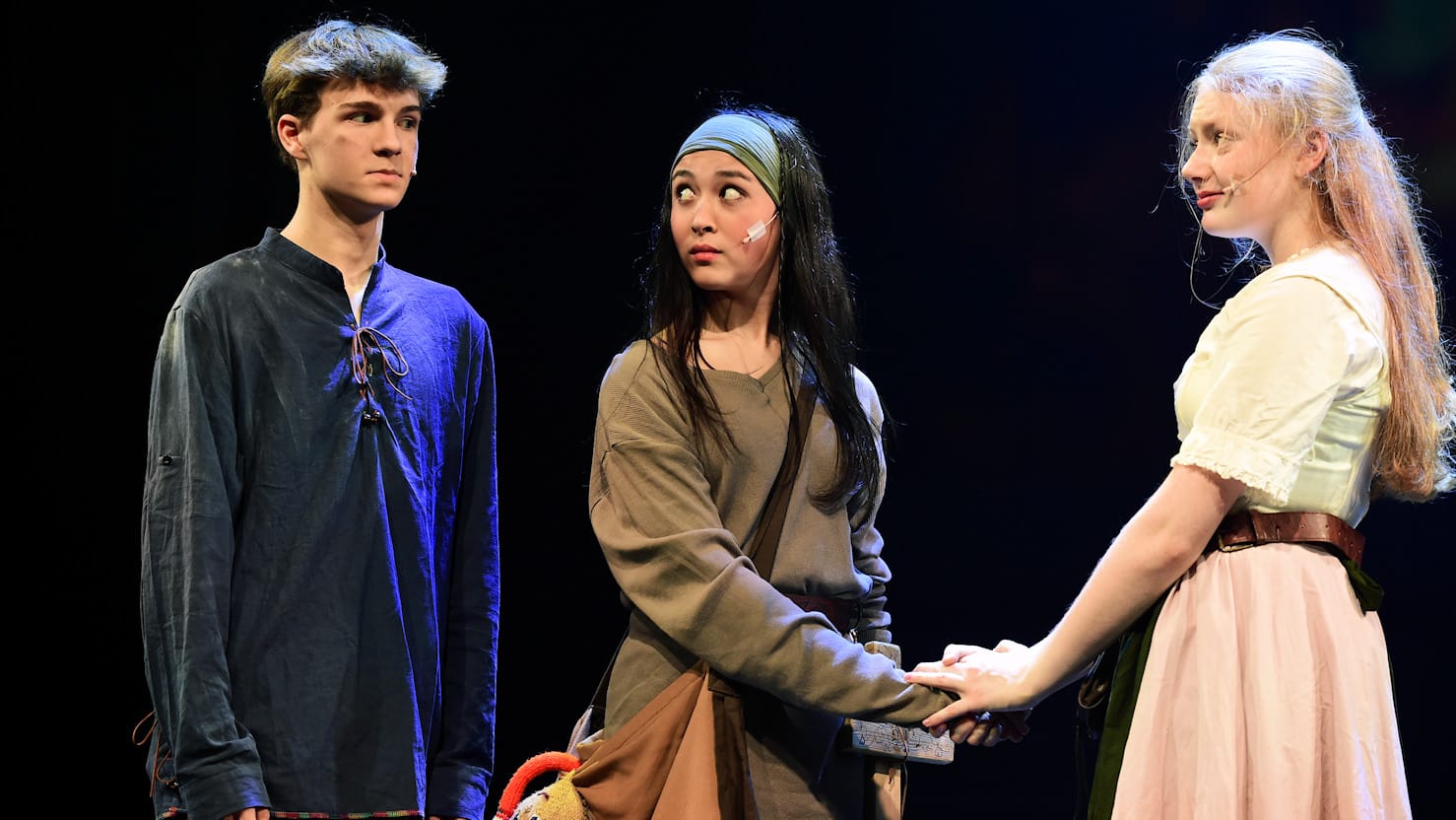 Szenenfoto von drei Schauspielern auf der Bühne.
