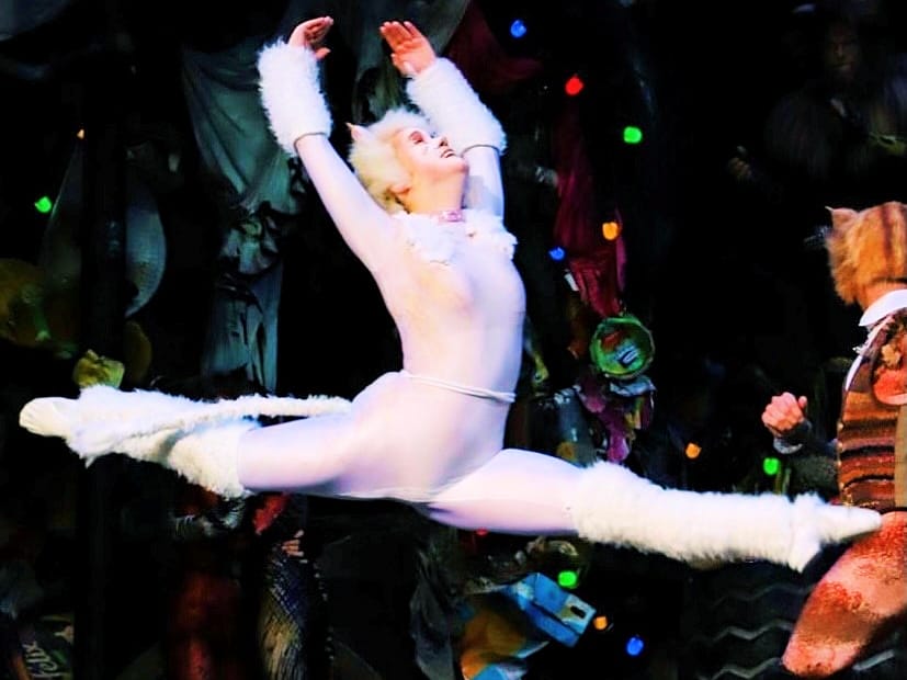 Tänzerin in eleganter Pose auf der Bühne.