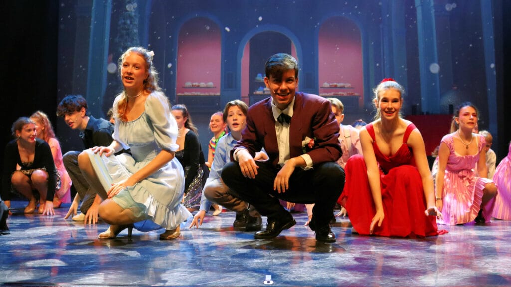 Jugendliche in Bühnenaufführung mit Tänzen.