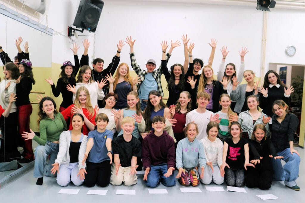 Gruppe junger Menschen mit erhobenen Händen