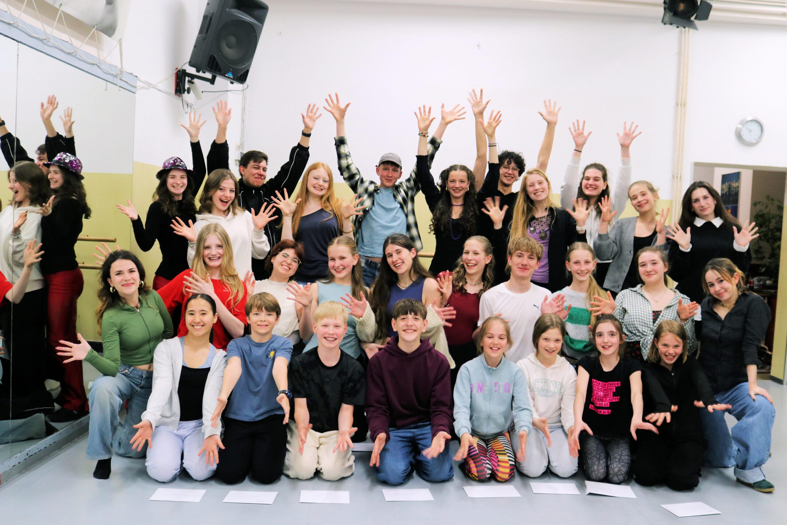 Gruppe junger Menschen mit erhobenen Händen